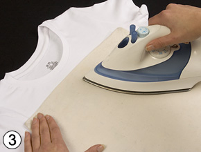 Ein Bügeleisen fixiert den abgedeckten Transfer auf dem Shirt.